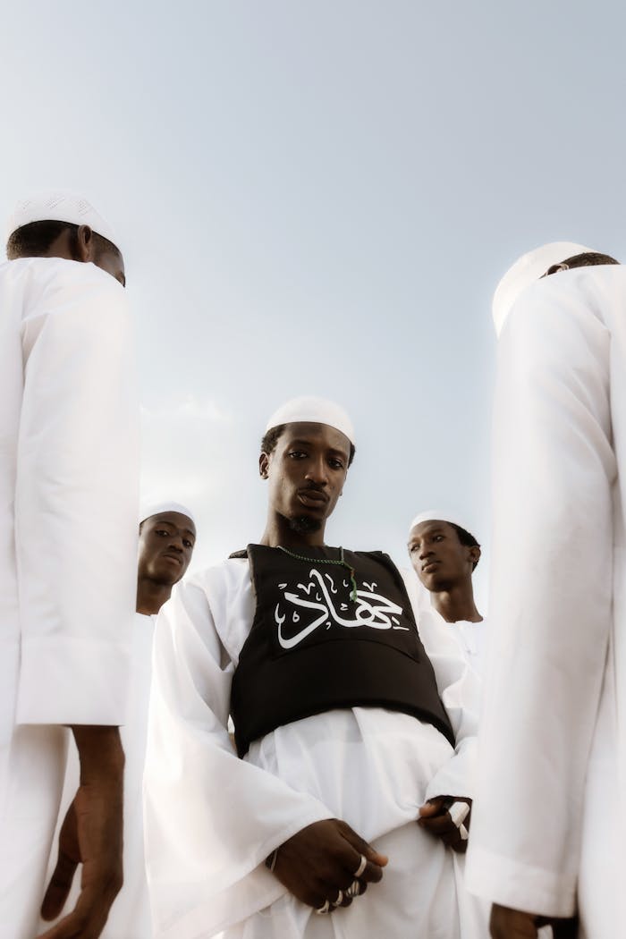A group of men in white traditional clothes standing outdoors, Nigeria.
