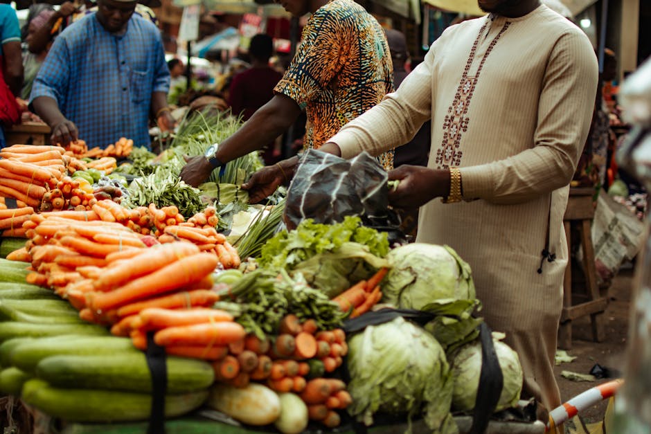 Bustling market scene with fresh vegetables and shoppers in colorful clothing.
